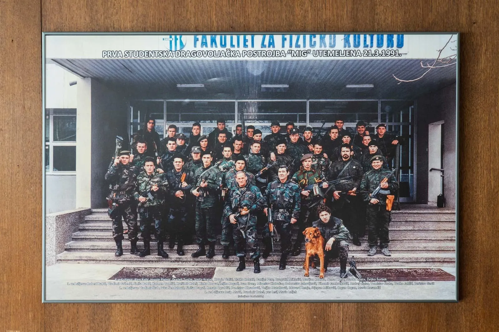 Uokvirena skupna fotografija pripadnika postrojbe MIG ispred ulaza u Fakultet za fizičku kulturu